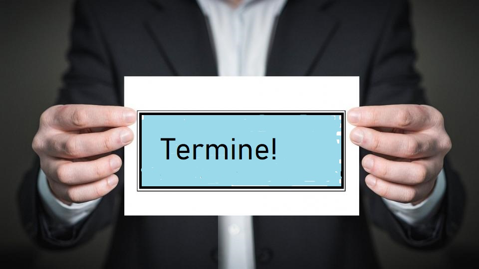 Person mit einem Schild Termine